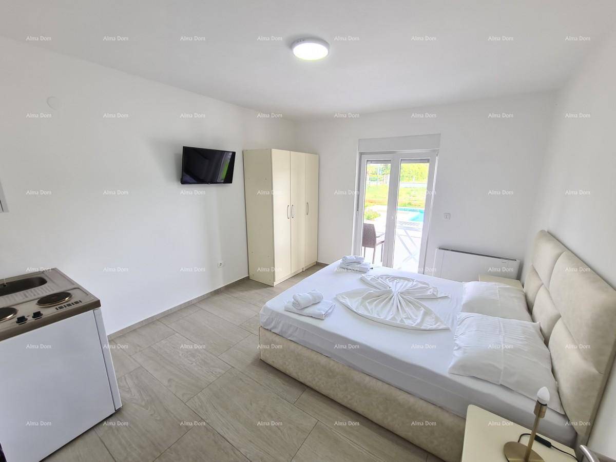 Gemütliches Schlafzimmer mit Doppelbett, kleiner Küchenzeile und Zugang zum Außenbereich.