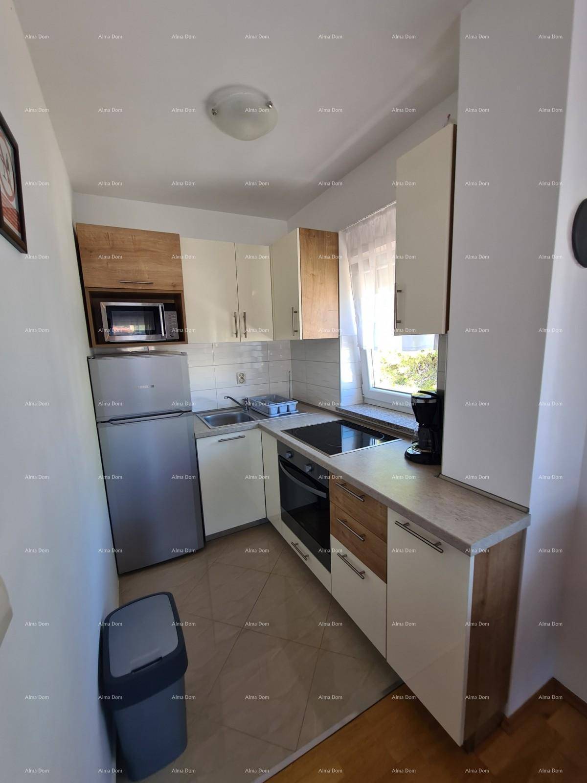 Funktionale Küche mit hellen und holzfarbenen Schränken, ausgestattet mit modernen Geräten und Fenster.