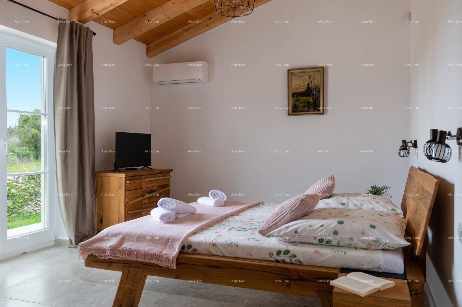 Schlafzimmer mit Holzbett, Dachschräge, Klimaanlage und Zugang zum Außenbereich.