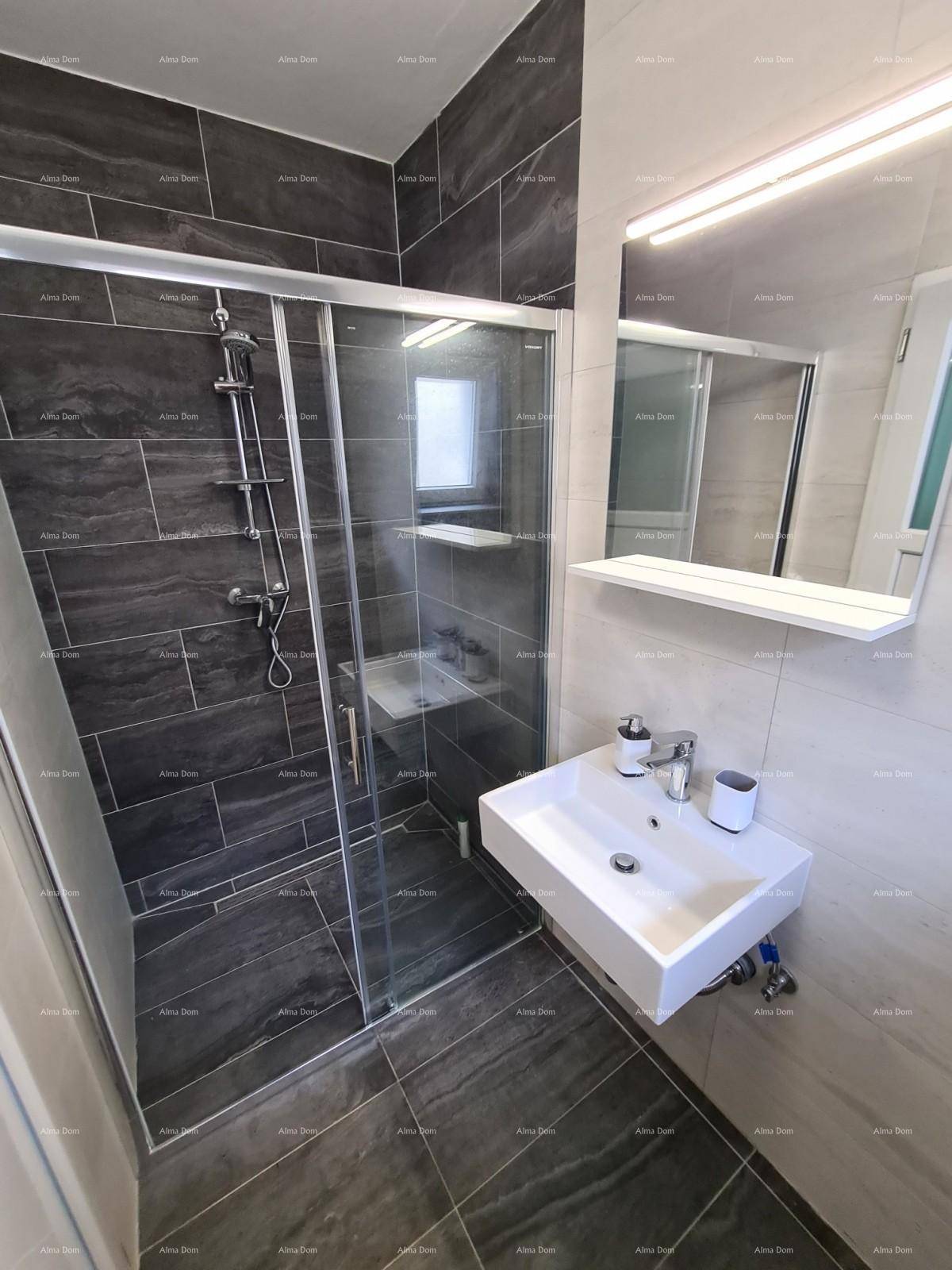 Modernes Badezimmer mit Duschkabine, Waschbecken und Spiegel, hell und dunkel gefliest.