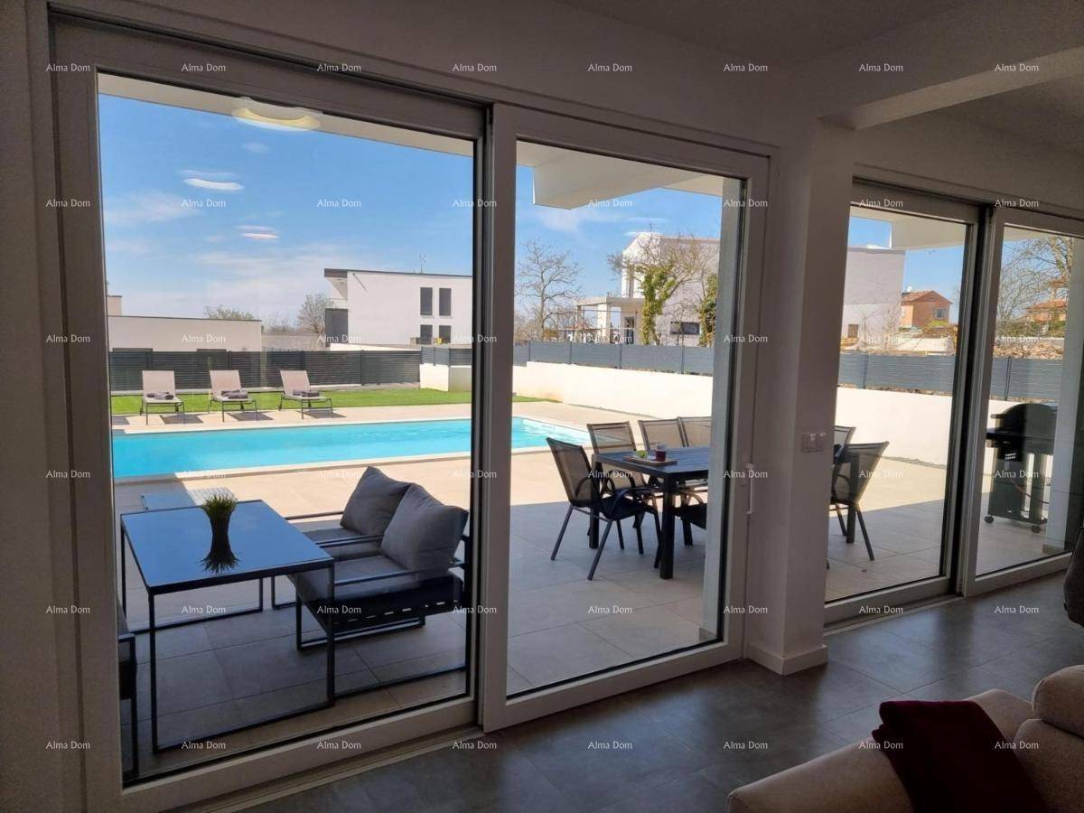Wohnzimmer mit großen Glasfronten bietet direkten Blick auf den Poolbereich und die Terrasse.