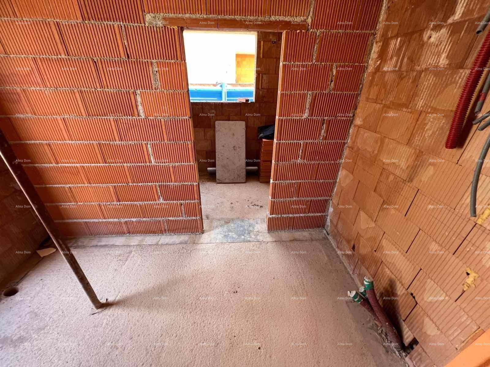 Innenraum im Rohbau mit Ziegelwänden und sichtbaren Installationen, bereit für den Ausbau.