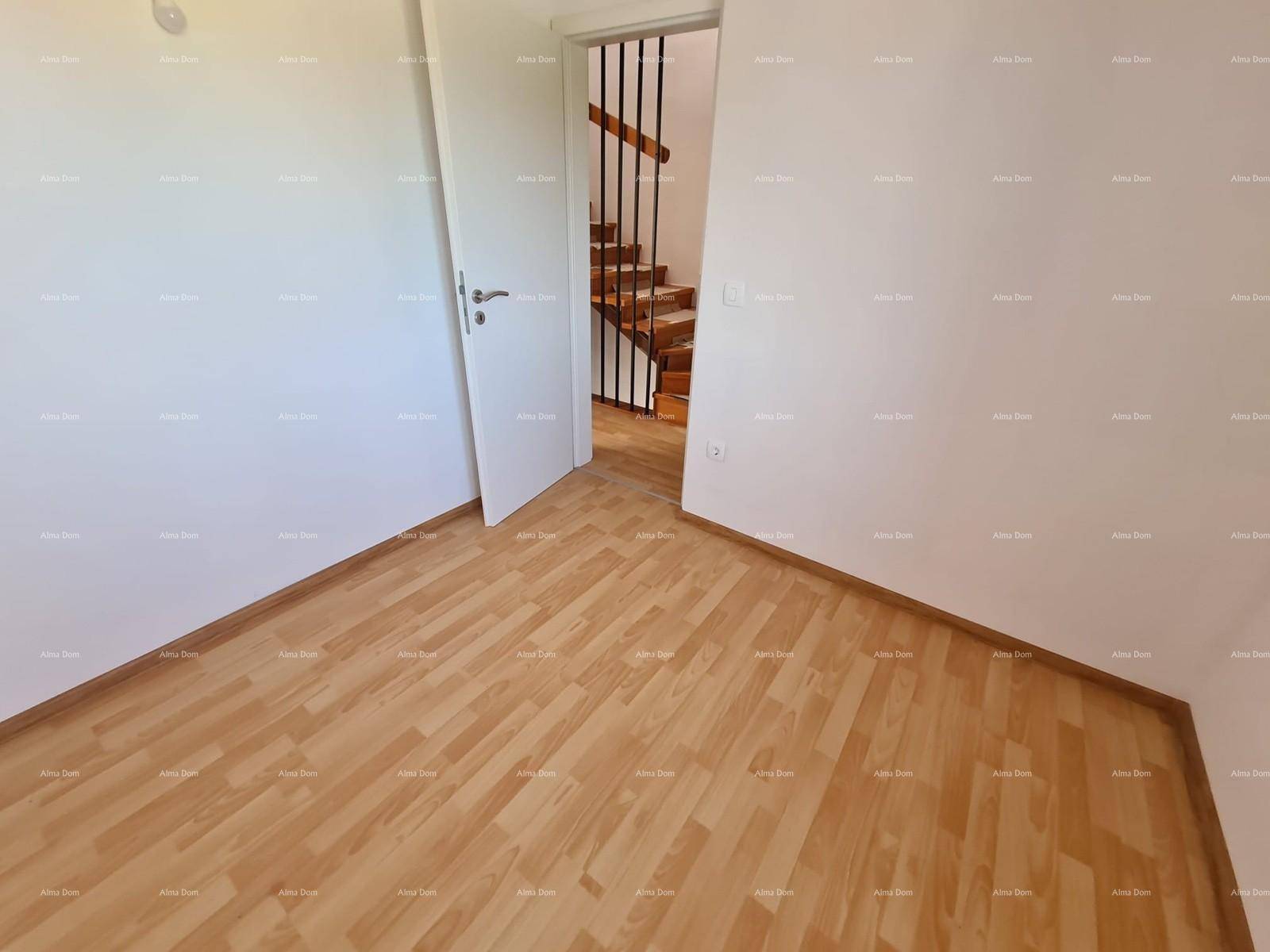 Leeres Schlafzimmer mit Laminatboden, weißen Wänden und Zugang zur Treppe.