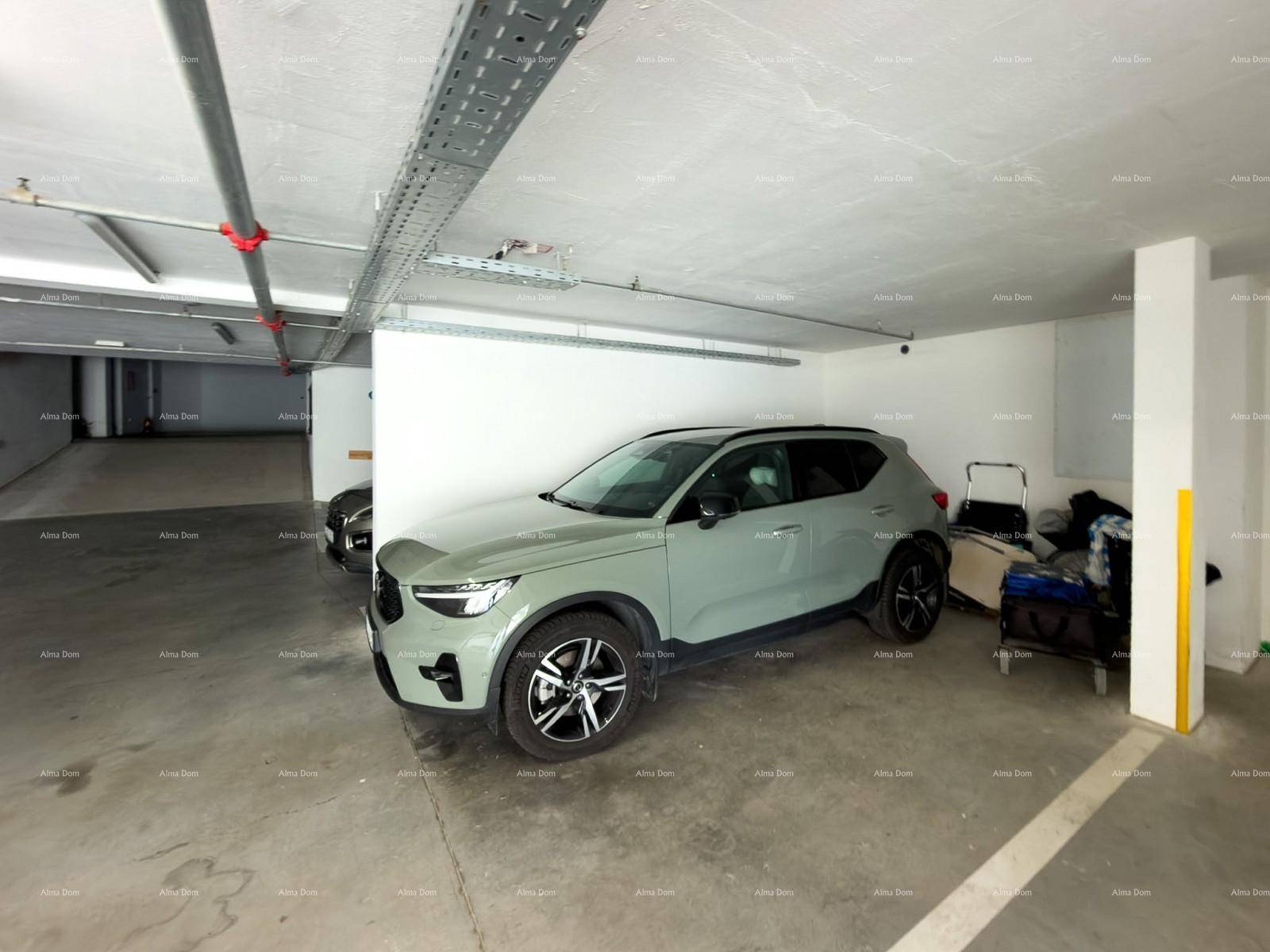Tiefgarage mit einem geparkten Auto und sichtbaren Installationen an der Decke.