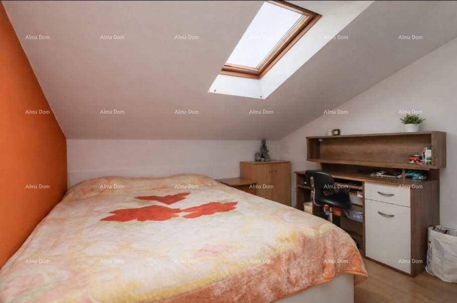 Gemütliches Schlafzimmer im Dachgeschoss mit Bett, Schreibtisch und einem Dachfenster für viel Licht.