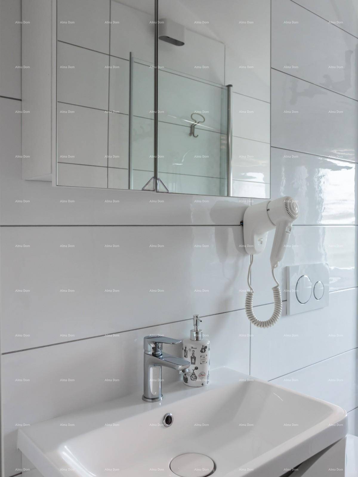 Detailansicht des Waschbereichs mit Einzelwaschbecken, Spiegelschrank und modernen Fliesen.