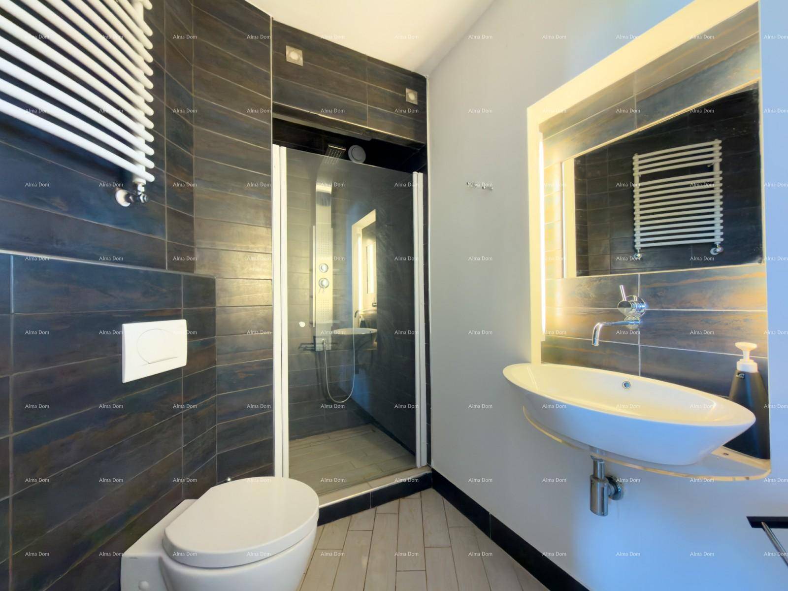 Modernes Badezimmer mit dunklen Fliesen, begehbarer Dusche und stilvollem Waschbecken.