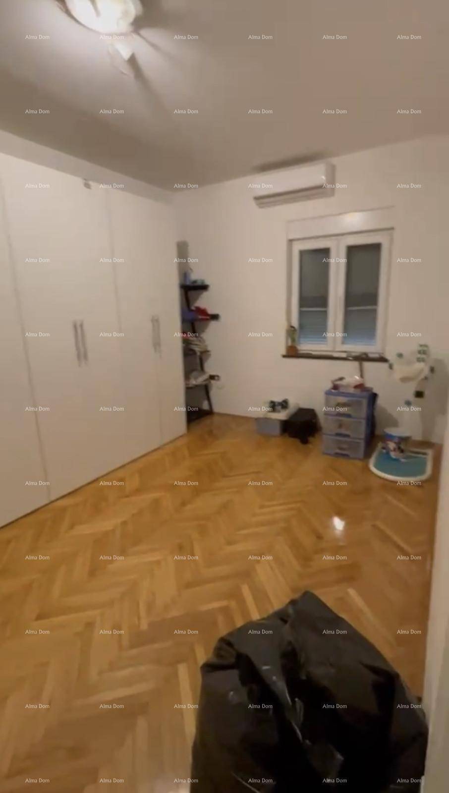 Geräumiges Schlafzimmer mit weißen Kleiderschränken, Fenster und Klimaanlage.