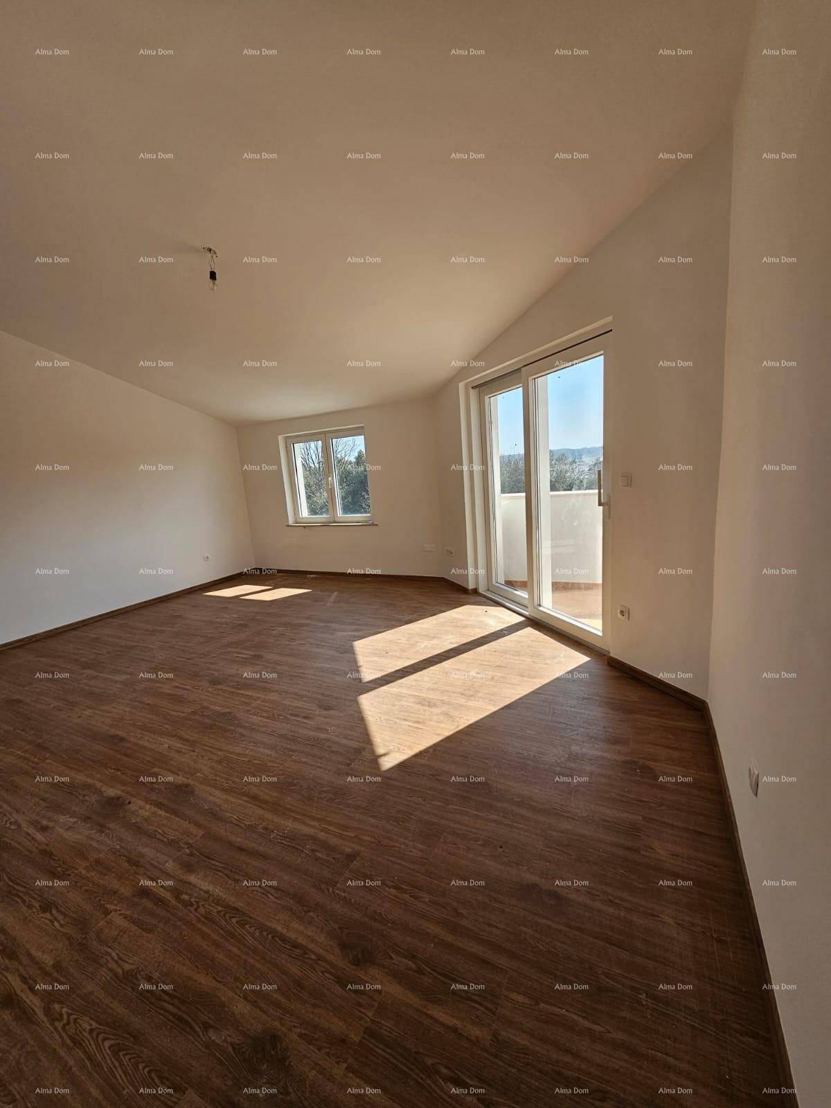Helles Schlafzimmer mit Holzboden, weißen Wänden und Zugang zu einem Balkon.