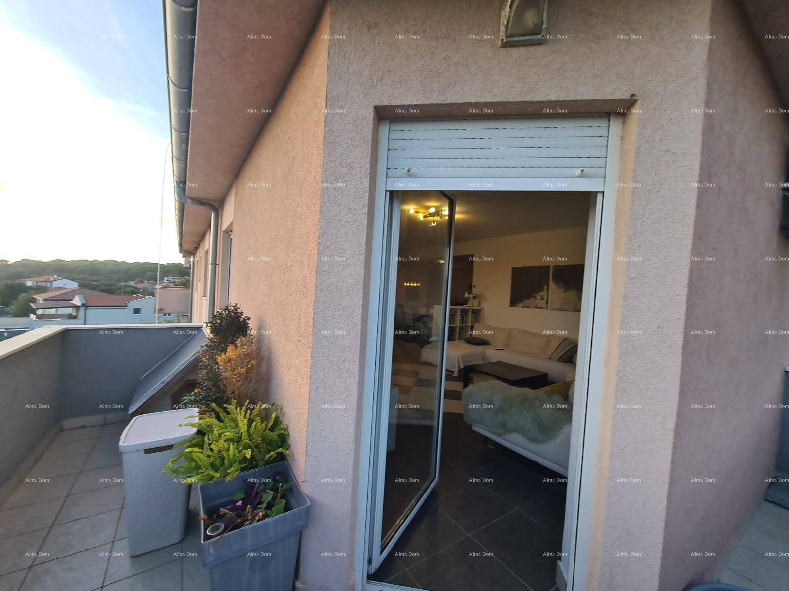 Balkon mit Fliesenboden und Blick in den Wohnbereich durch die offene Tür.