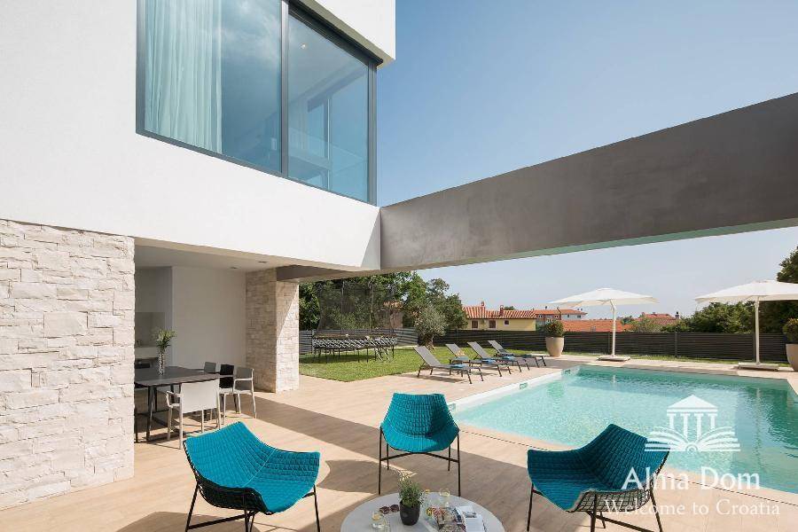 Gemütliche Terrasse mit Poolzugang und modernen Möbeln, umgeben von einer gepflegten Gartenanlage.