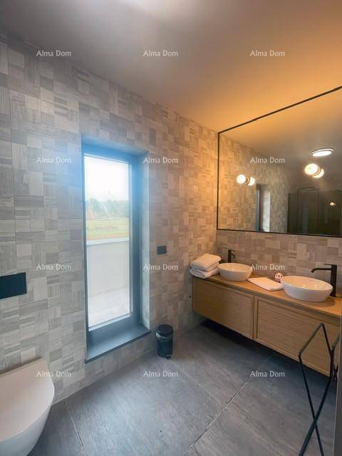 Modernes Badezimmer mit Doppelwaschbecken, Wand-WC und großem Fenster für Tageslicht.