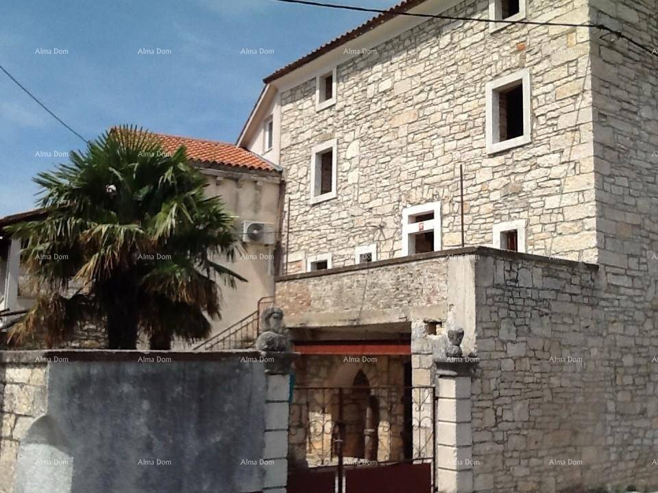 Nahaufnahme des Steinhauses mit traditioneller Architektur, Palmen und einer Klimaanlage an der Fassade.