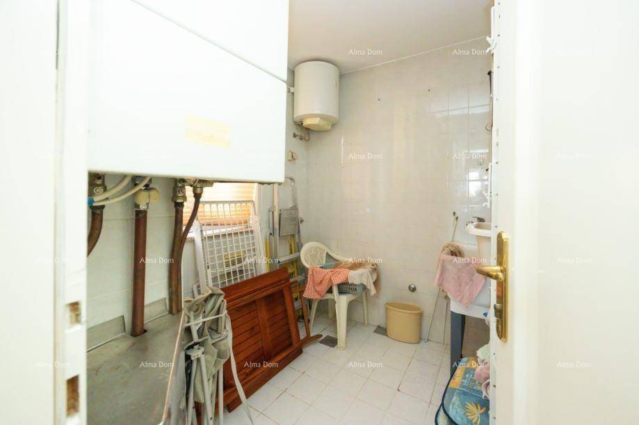 Kleiner Hauswirtschaftsraum mit Warmwasserboiler und Stauraum.