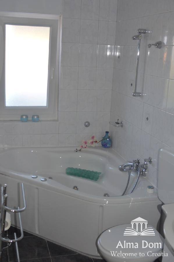Helles Badezimmer mit Eckbadewanne und weißen Fliesen, ideal zum Entspannen.