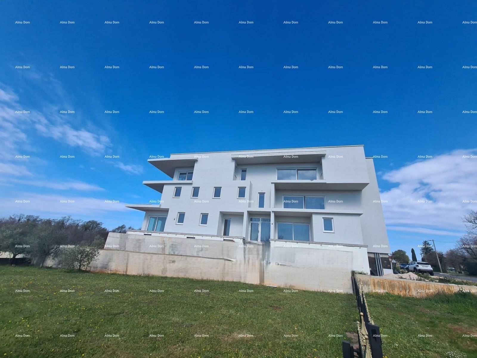 Moderne Gebäudefassade im Bauzustand mit klarem Himmel und grüner Umgebung.