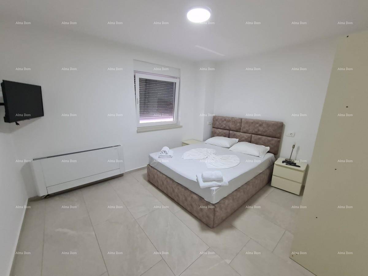 Helles Schlafzimmer mit Doppelbett, Nachttisch und Fernseher an der Wand.