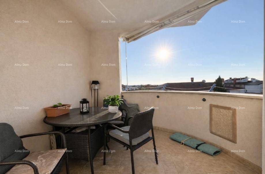 Sonniger Balkon mit Outdoor-Sitzgelegenheiten und weitem Blick über die Dächer der Stadt.