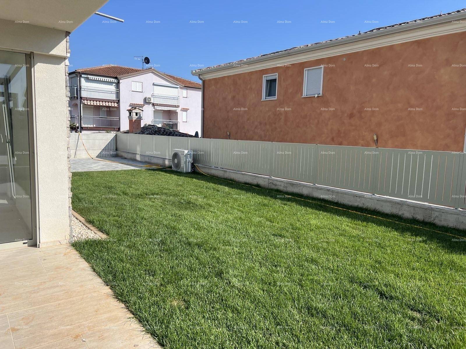 Gepflegter Rasenbereich neben dem Haus mit einer Klimaanlage an der Wand.