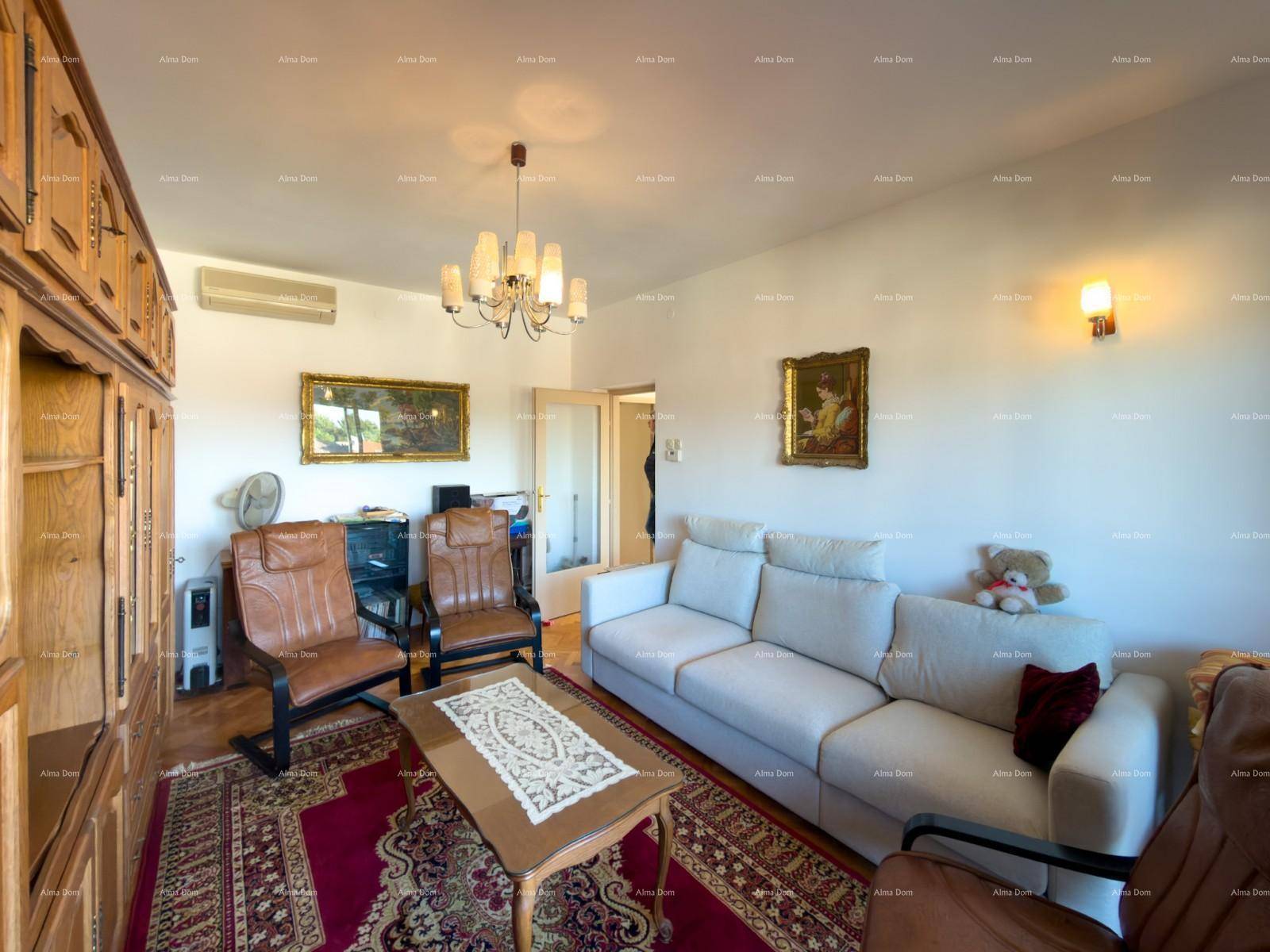 Wohnzimmer mit Klimaanlage, Holzmöbeln und einem bequemen Sofa, gut beleuchtet.