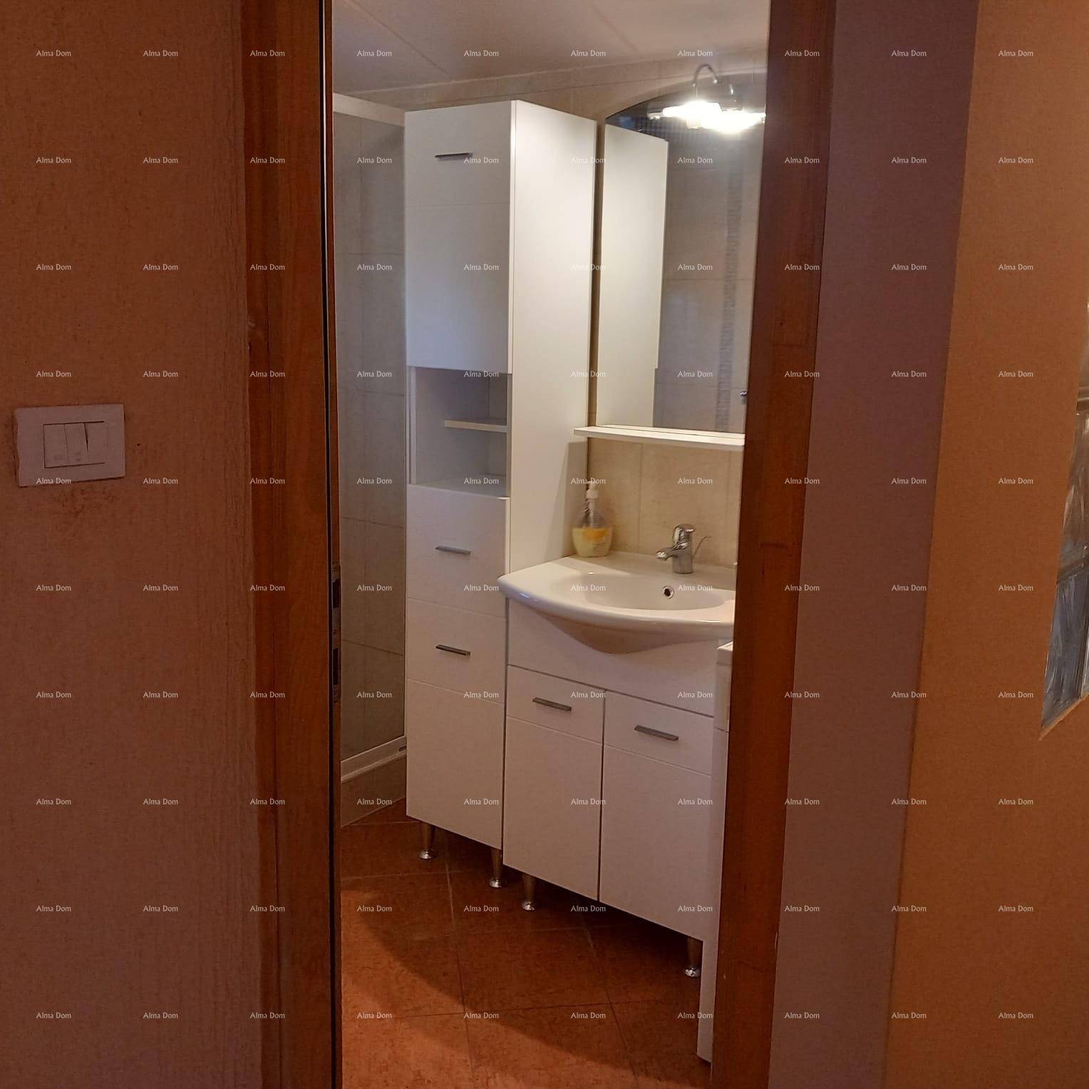 Modernes Badezimmer mit weißem Waschtisch, Spiegelschrank und Duschkabine.