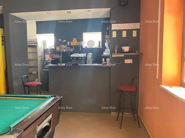 Detailansicht der Bar mit Theke, Hockern und einem Kühlschrank für Getränke.