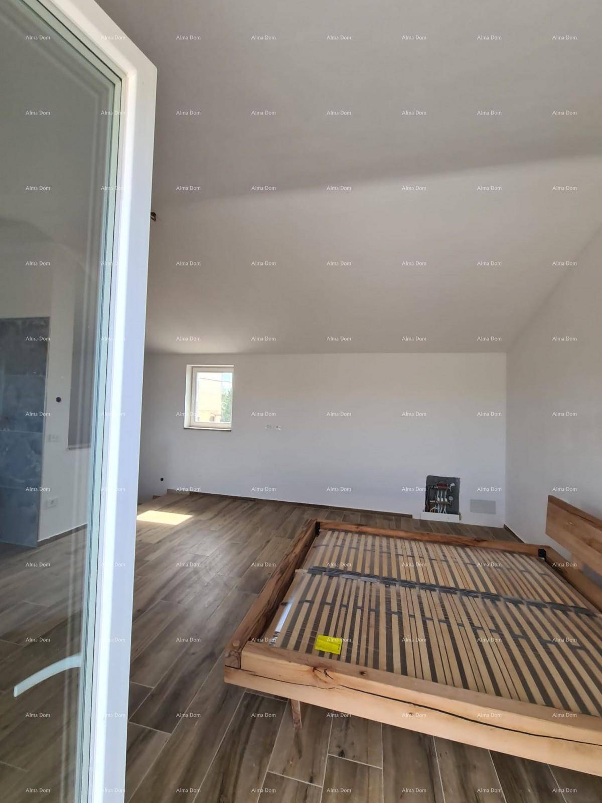 Helles Schlafzimmer mit Holzbettrahmen und Holzboden in einem Neubau.