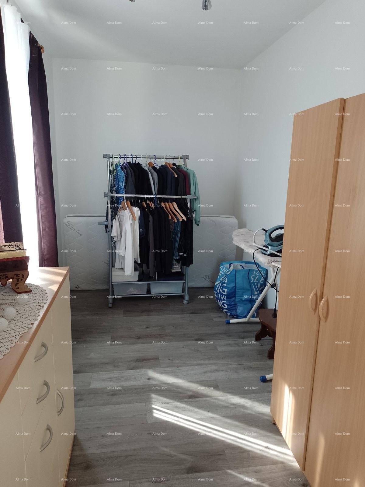 Helles Zimmer mit Laminatboden, Kleiderstange und Schrank, ideal als Ankleidezimmer.
