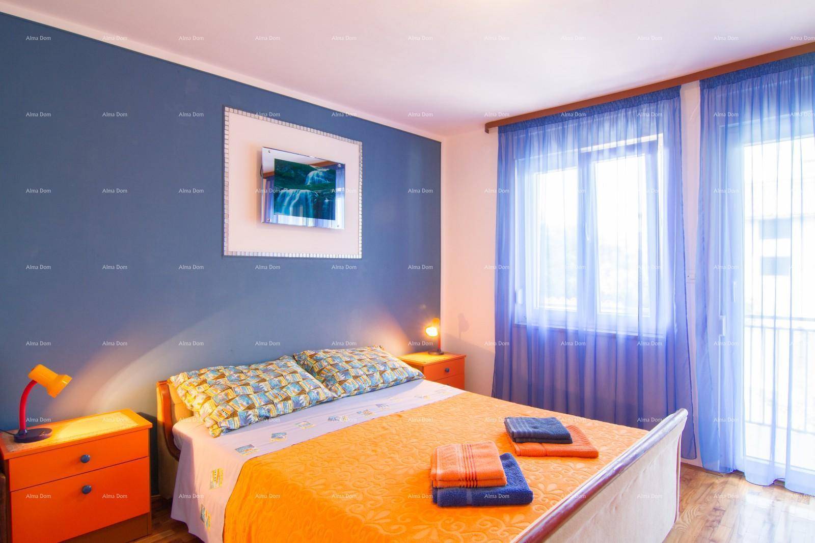 Helles Schlafzimmer mit blauer Wand, orangefarbenen Möbeln und Zugang zum Balkon.