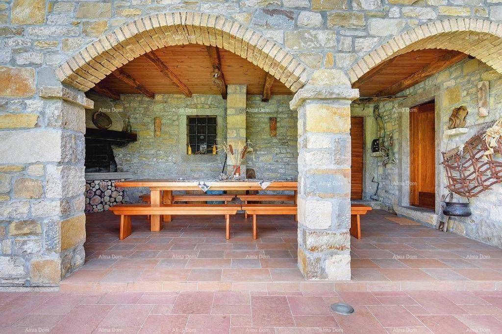 Rustikaler Essbereich im Freien mit Holztisch und Bänken, umgeben von Steinmauern und Bögen.
