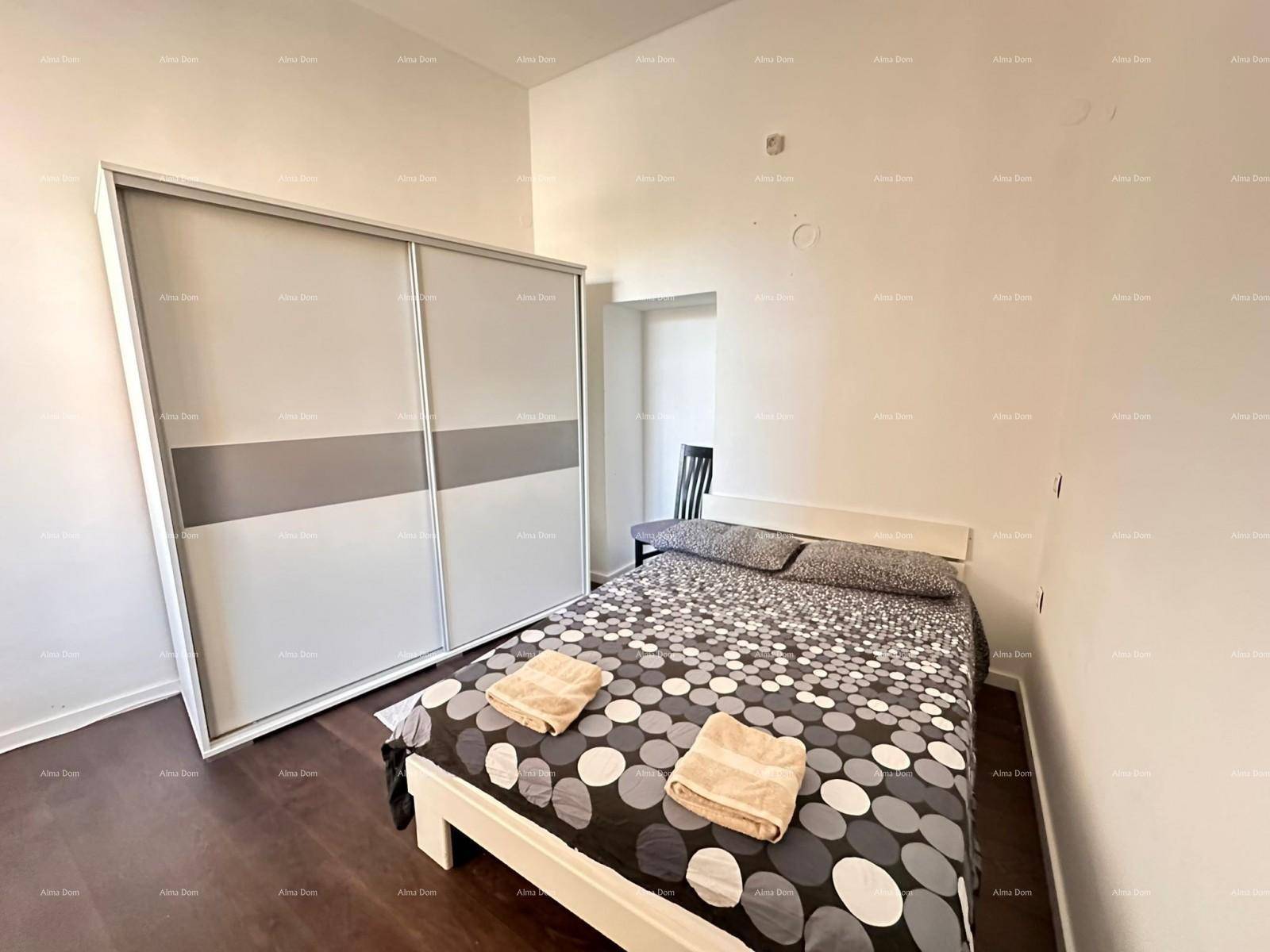 Schlafzimmer mit Doppelbett, modernem Schiebetürenschrank und dunklem Holzboden.