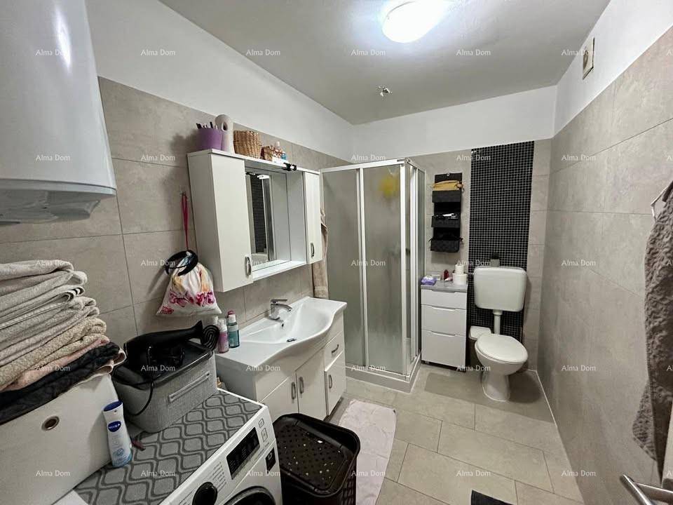 Helles Badezimmer mit Duschkabine, WC, Waschbecken und Fliesen an Wänden und Boden.
