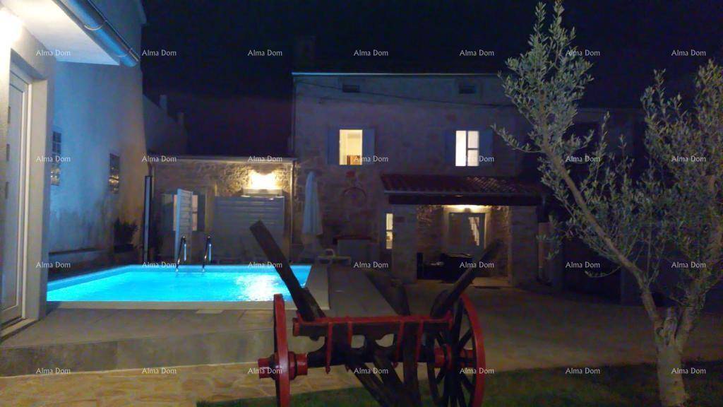 Nächtliche Ansicht des Anwesens mit beleuchtetem Pool und dem charmanten Steinhaus im Hintergrund.