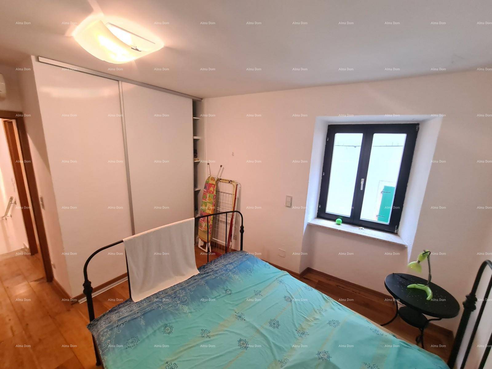 Gemütliches Schlafzimmer mit Bett, Einbauschrank und Fenster, ausgestattet mit Holzboden.