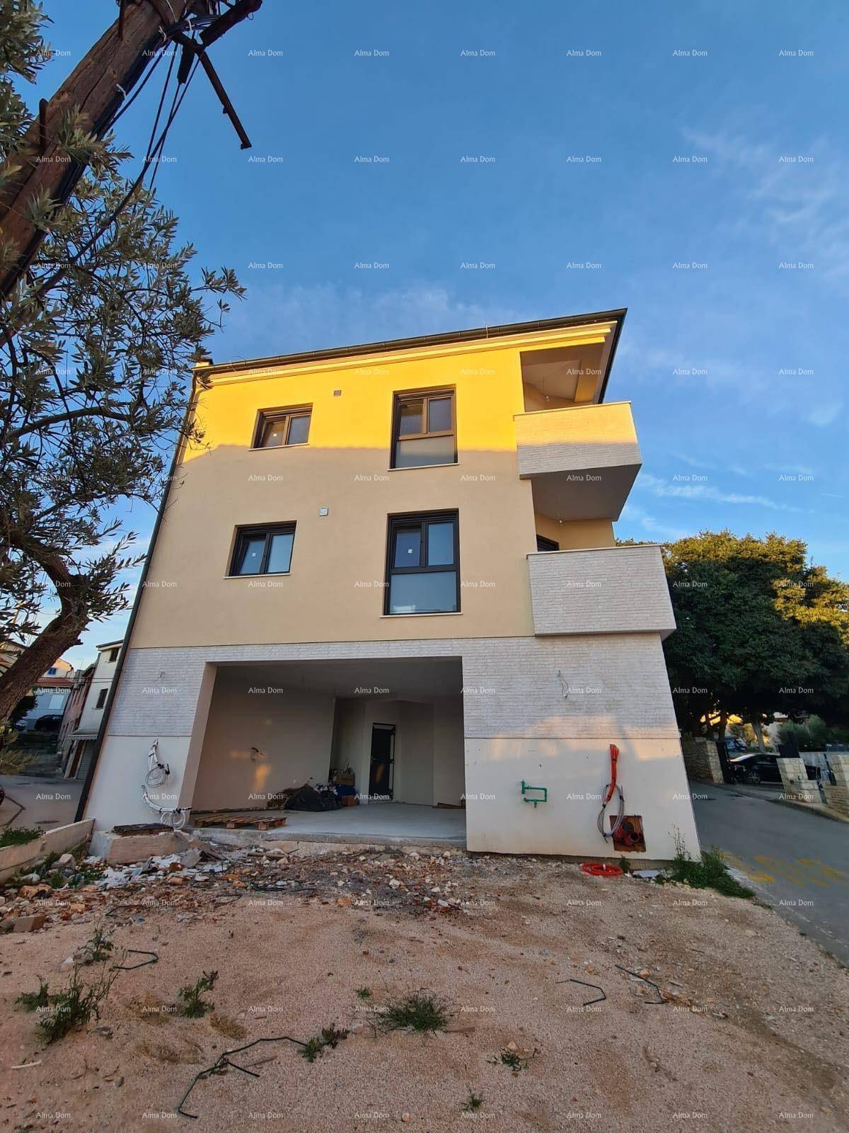 Neubau mit zeitgenössischer Architektur und Balkonen, umgeben von Baustellenmaterial.