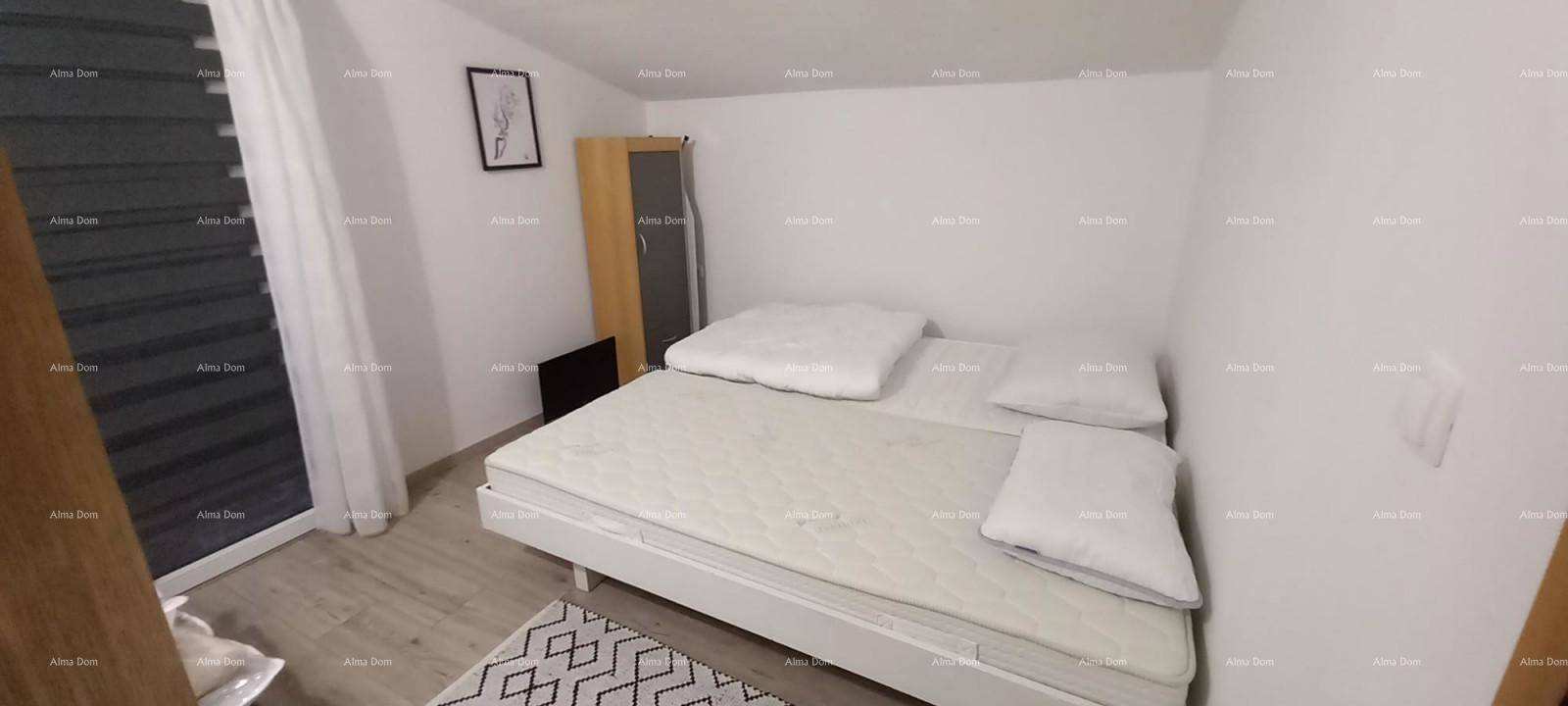 Gemütliches Schlafzimmer mit Doppelbett, Teppich und schräger Decke.