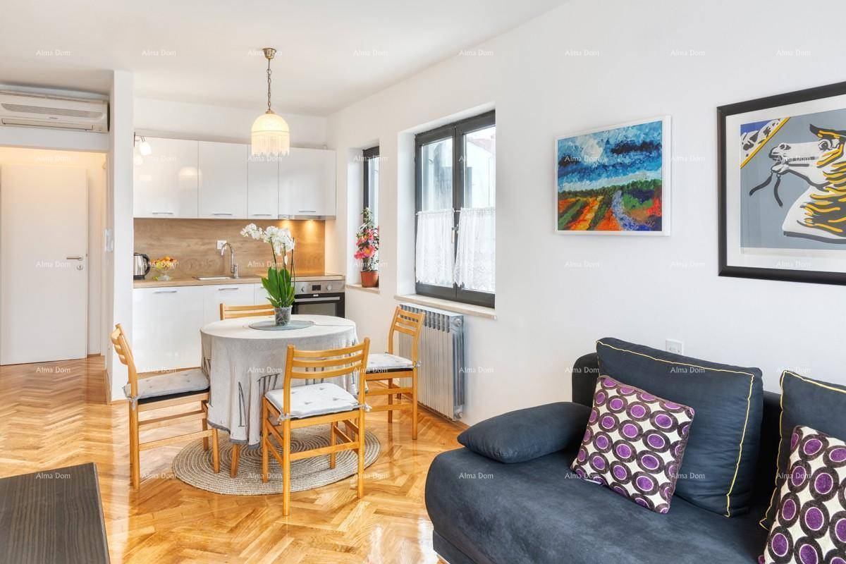 Offener Wohn- und Essbereich mit Sofa, Holzboden und moderner Küche im Hintergrund.