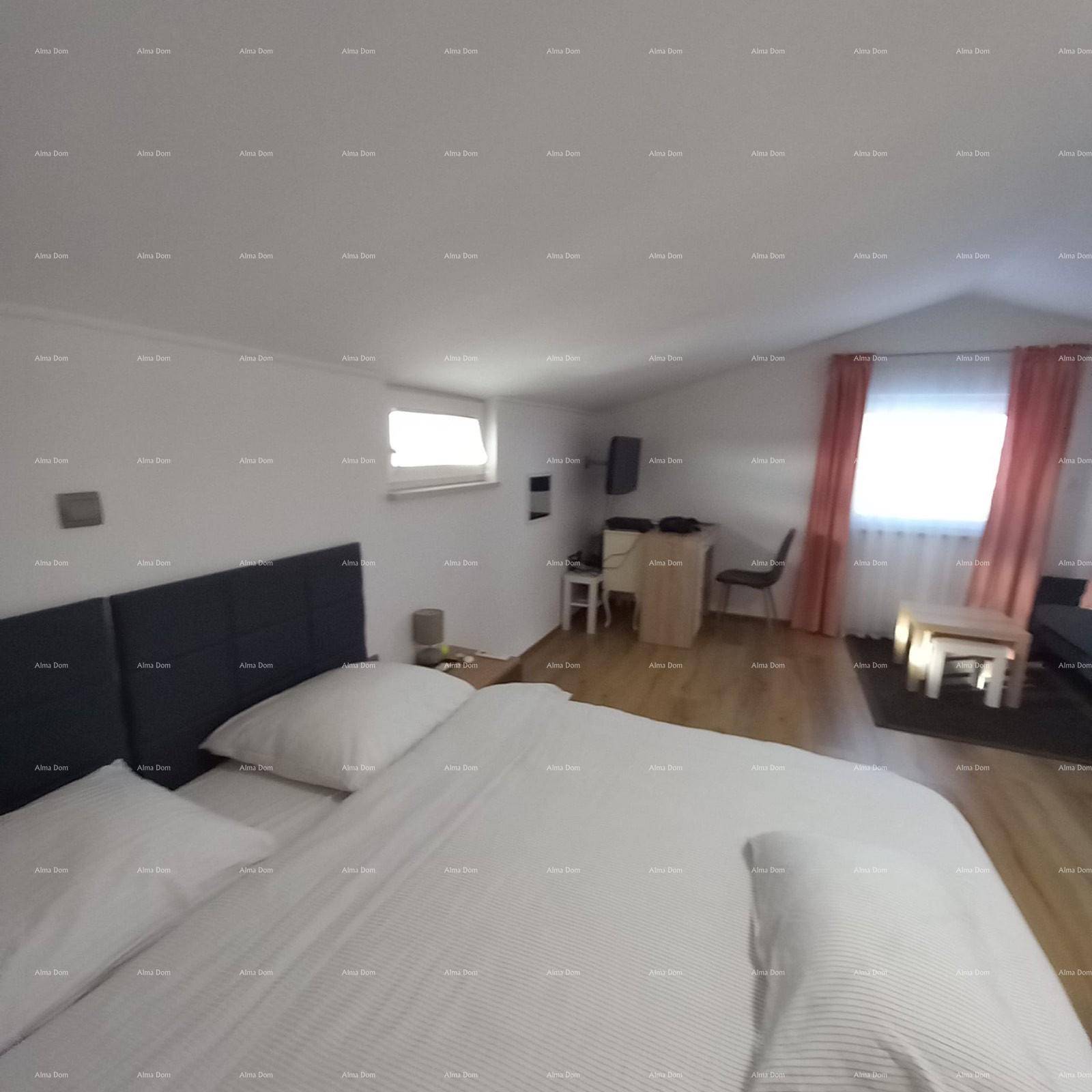 Schlafzimmer im Dachgeschoss mit Doppelbett, Dachschräge und kleinem Fenster.