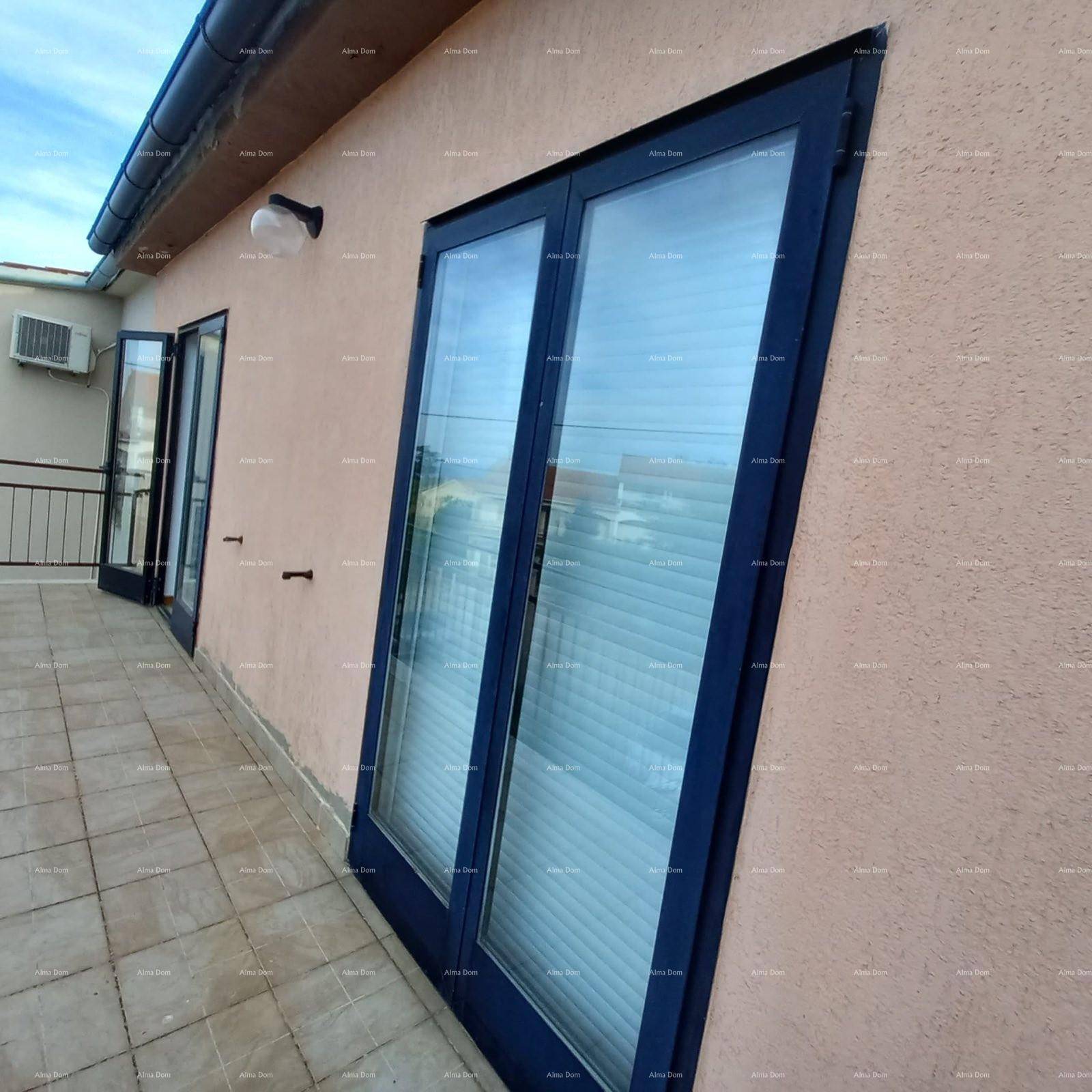 Balkon mit Fliesenboden und großen Fenstern, die viel Licht in die Innenräume lassen.