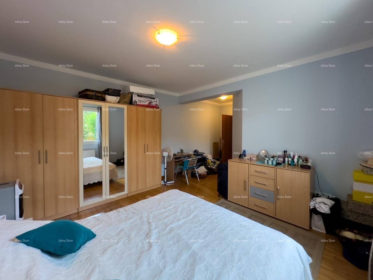 Großes Schlafzimmer mit viel Stauraum durch Einbauschränke und separatem Arbeitsbereich, praktisch eingerichtet.