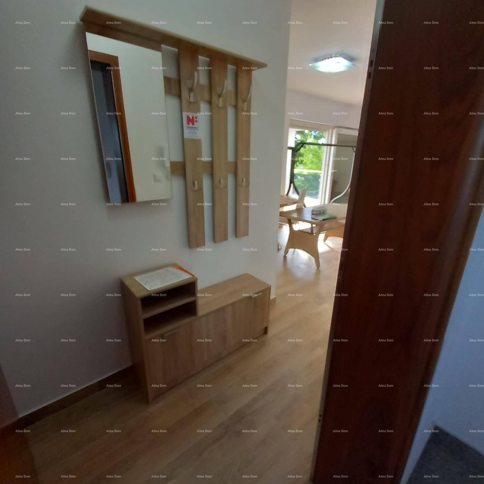 Heller Flur mit Holzfußboden, Spiegel und Garderobe, der in einen weiteren Wohnbereich führt.