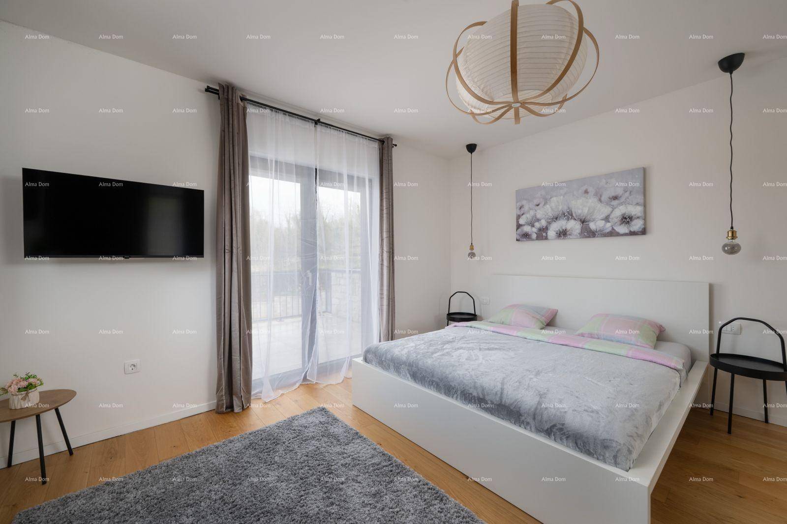Komfortables Schlafzimmer mit Doppelbett, Holzboden und Zugang zu einem Balkon.
