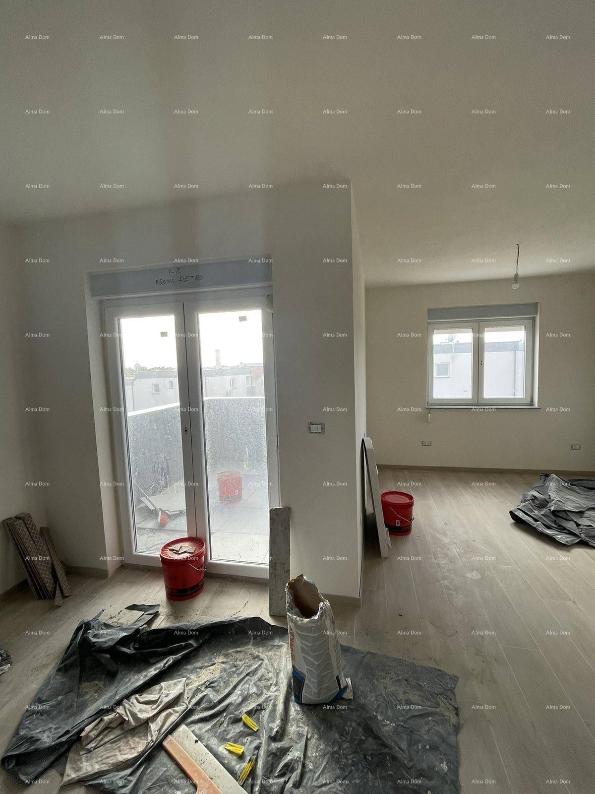 Heller Wohnbereich im Rohbau mit großem Balkonfenster, Fliesenboden und Baumaterialien.