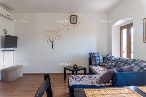 Wohnzimmer mit blauem Sofa, Fernseher und dekorativer Wandgestaltung, bietet eine entspannte Atmosphäre.