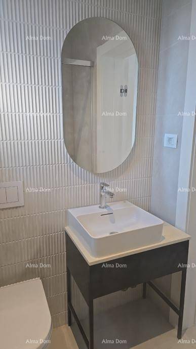 Helles Badezimmer mit modernem Waschbecken, ovalem Spiegel und strukturierten Wandfliesen.