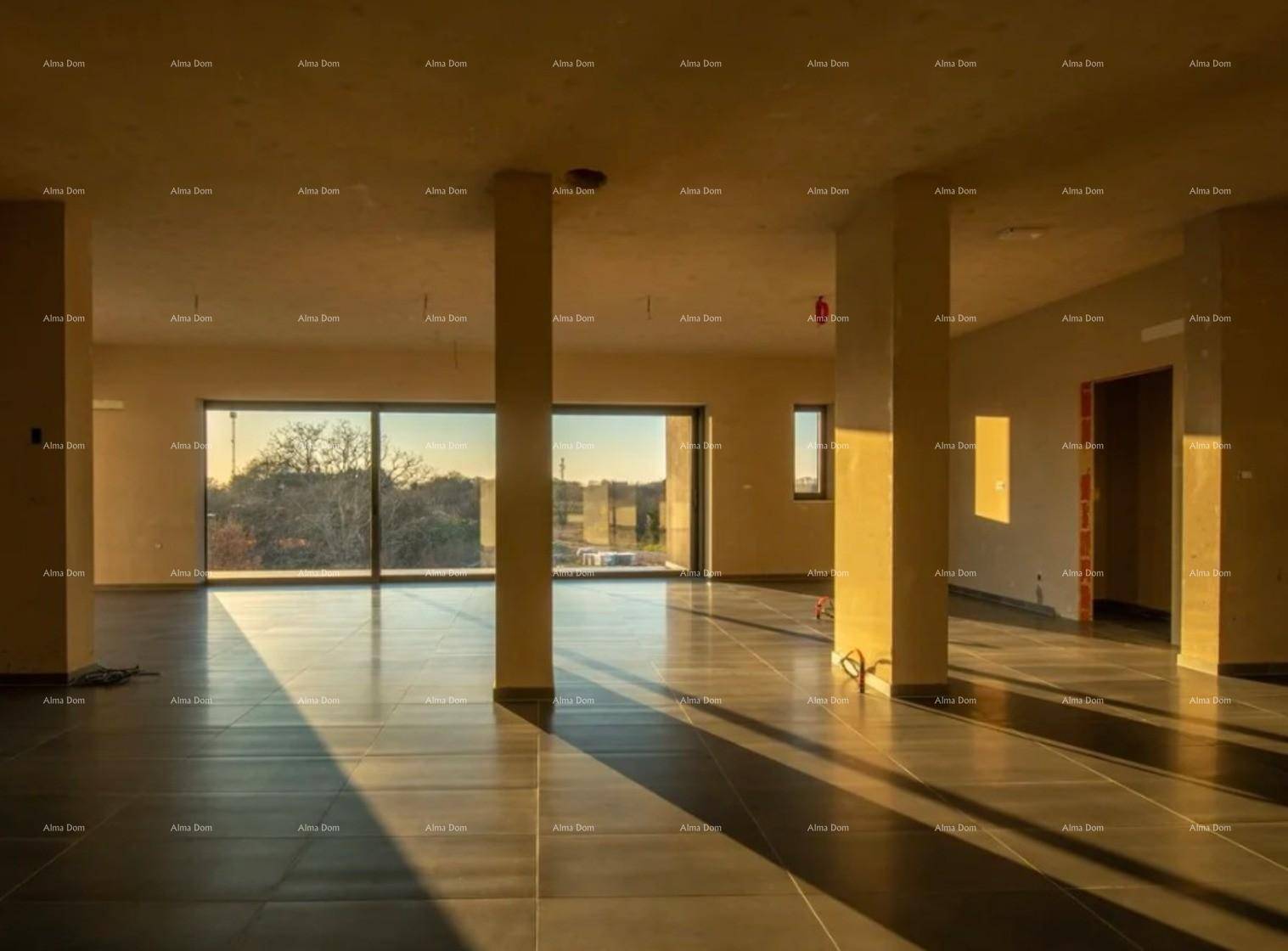 Großer, sonniger Wohnraum im Rohbau mit Säulen und weiten Fenstern, die viel Licht spenden.