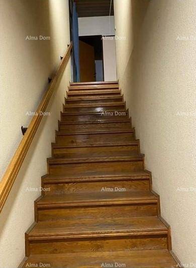 Holztreppe mit hellem Geländer führt in die obere Etage.