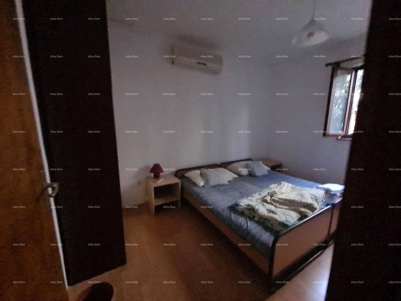 Schlafzimmer mit Doppelbett, Nachttischen und Klimaanlage an der Wand.