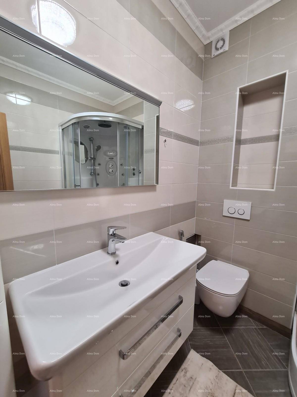 Waschbecken mit modernem Unterschrank und Wand-WC in einem hell gefliesten Badezimmer.