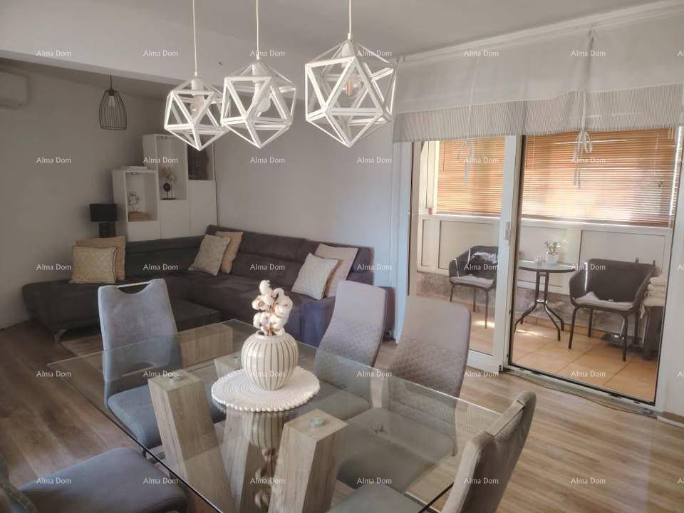Gemütlicher Wohn-Essbereich mit Zugang zu einem kleinen Balkon, ausgestattet mit modernen Hängelampen.